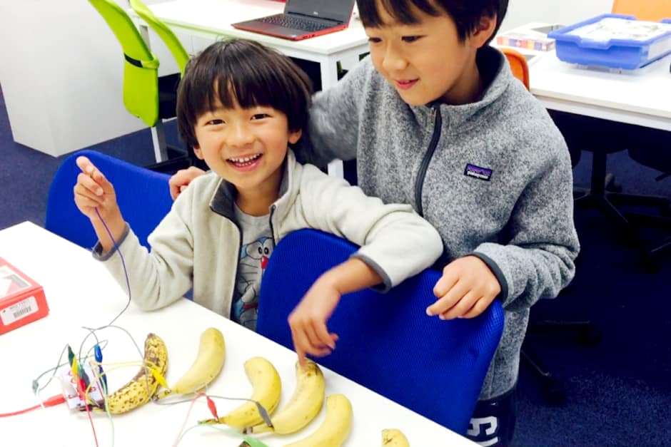Makey Makeyでバナナを楽器に変えて笑う生徒2人