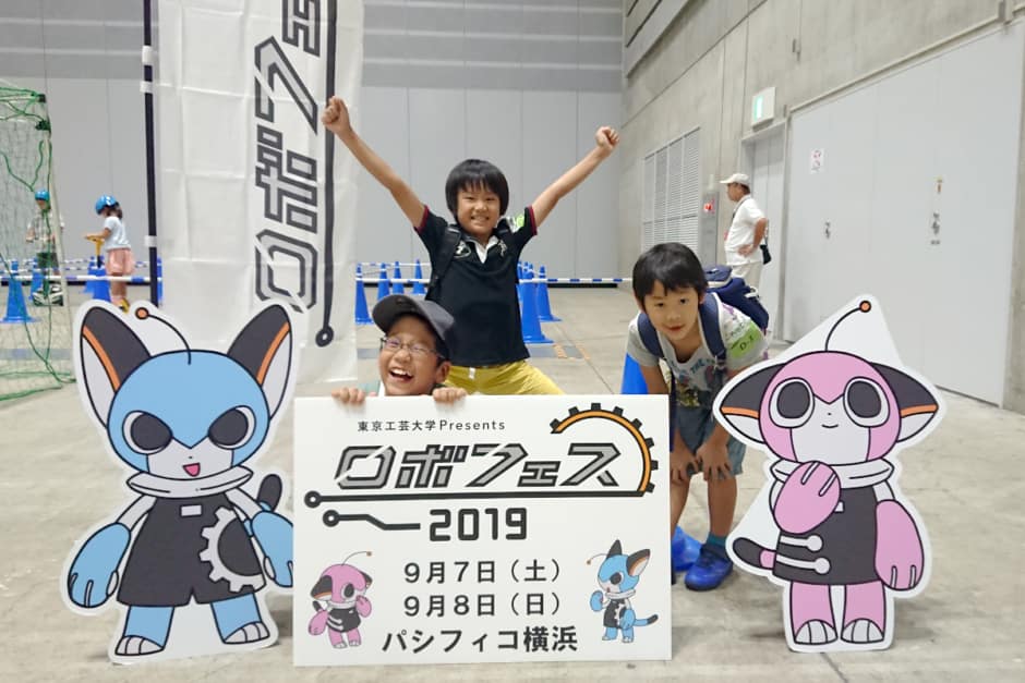 ロボフェスの前で記念撮影をする3人の生徒